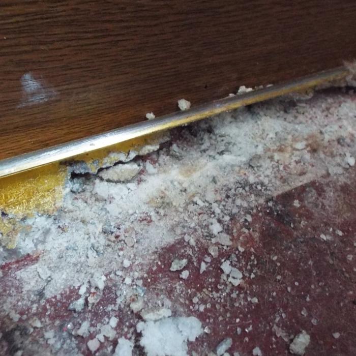 Damp magnesium oxychloride flooring causing corrosion of carpet grippers. Magnesite flooring is not commonly used at the current time but was very popular for domestic applications in the period 1920 to 1940, and for Local Authority housing between 1945 and 1960. Magnasite was commonly applied on top of concrete ground floor slabs and is made from a mixture of calcined magnesite and magnesium chloride solution with various fillers (e.g. wood flour, sawdust, asbestos). It was typically laid between 10 and 25mm thick, but two coat applications could be up to 50mm thick. Magnesite floorings are very vulnerable to dampness and if there is any doubt about moisture protection, it should be replaced. 
&nbsp;
Where in contact with moisture magnesite produces a weak solution of hydrochloric acid due to the presence of chlorides which may migrate from the magnesite into the concrete below and corrode any reinforcement, gas or water pipes.
&nbsp;
&nbsp;
Magnesite is also electrically conductive therefore using electrical resistance meters will give a full scale damp reading even if the material is dry.&nbsp; Most magnesite floors are now coming to the end of their life, and only if they can be guaranteed to remain unaffected by moisture can they be used as a screed to receive other floorings, otherwise the flooring should be replaced.&nbsp;Crucially, because magnesite is water soluble, it will return to its previous state if exposed to enough water.&nbsp;